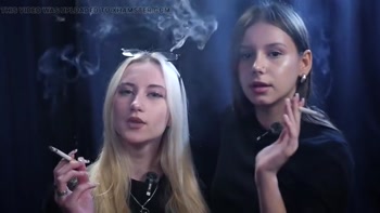 Two Women Smoking Together in a Dark Studio with Soft Blue Lighting
