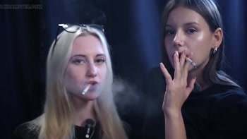 Two Women Smoking Together in a Dark Studio with Soft Blue Lighting
