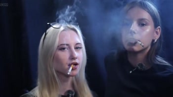 Two Women Smoking Together in a Dark Studio with Soft Blue Lighting