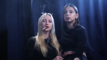 Two Women Smoking Together in a Dark Studio with Soft Blue Lighting
