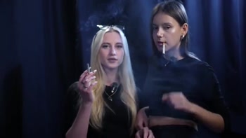 Two Women Smoking Together in a Dark Studio with Soft Blue Lighting
