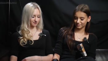 Two Women in Black Outfits Sharing a Cigarette with Slow Smoke and Playful Interaction