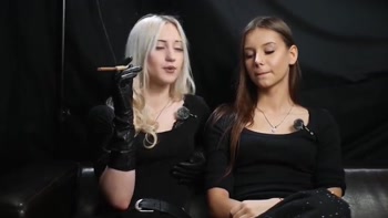 Two Women in Black Outfits Sharing a Cigarette with Slow Smoke and Playful Interaction