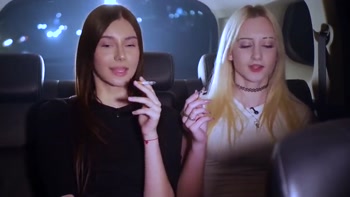 Two Women Smoking and Chatting in a Car at Night